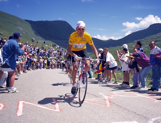 Jan Ullrich auf einem Rennrad auf einer von Fans gesäumten Bergstraße. Jan Ullrich auf einem Rennrad auf einer von Fans gesäumten Bergstraße.