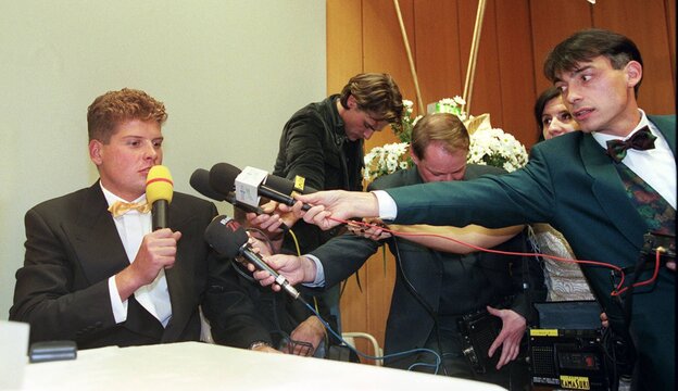 Jan Ullrich mit Reportern mit Mikrofonen. Jan Ullrich mit Reportern mit Mikrofonen.