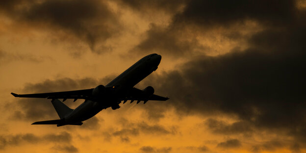 Ein Flugzeug vor einem dunklen Himmel.