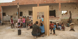 Puppenspieler vor einer zerstörten Schule