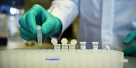 Eine Mann hält eine Probe in einem Labor in der Hand