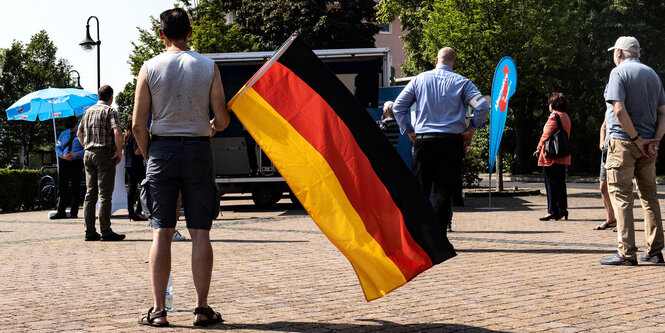 Kleine Kundgebung mit Deutschlandfahne.