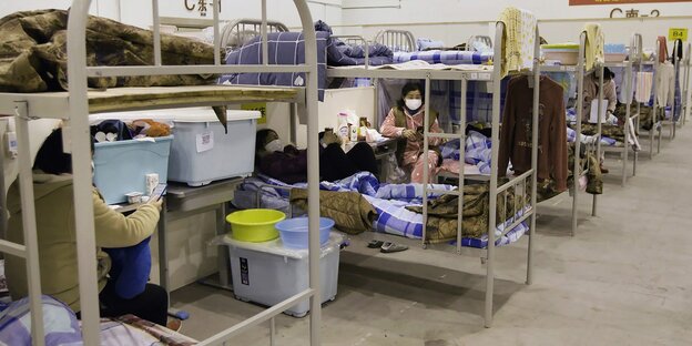 Szenenbild der Doku: improvisiertes Krankenhaus mit Hochbetten
