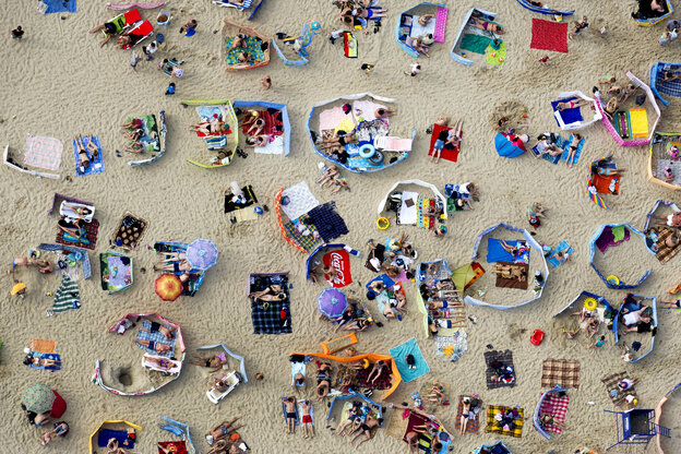 Menschenmenge und ihre bunten Mitbringsel aus der Luft gesehen am Strand