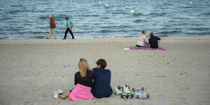 Ein Paar sitzt am Strand