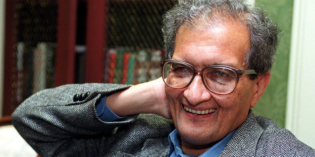 Amartya Sen hält sich eine Hand in den Nacken