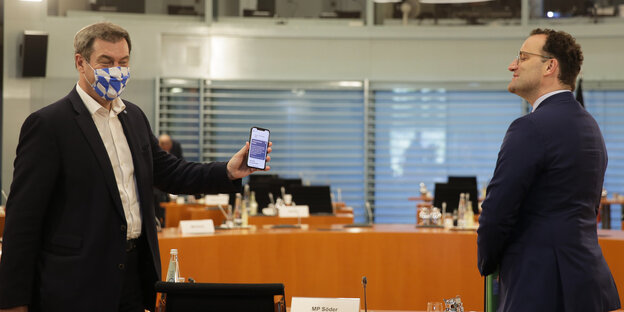 Jens Spahn strahlt und hält ein Smartphone in die Kamera