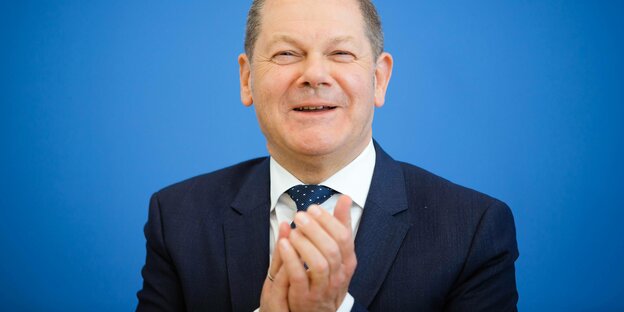 Finanzminister Olaf Scholz klatscht und lacht.