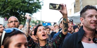 Menschen beim sommerlichen Musikhören im Freien in Berlin