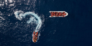 2 Boote mit Menschen in Rettungswesten