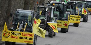 Traktoren mit Anti-Atomkraft-Transparenten fahren auf einer Straße