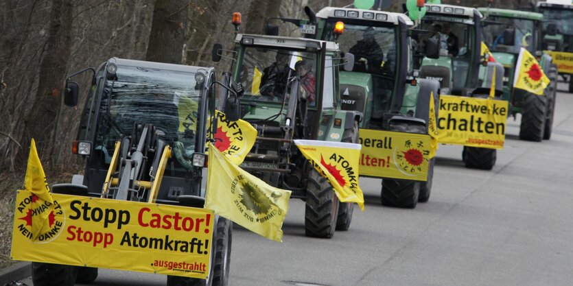 Traktoren mit Anti-Atomkraft-Transparenten fahren auf einer Straße