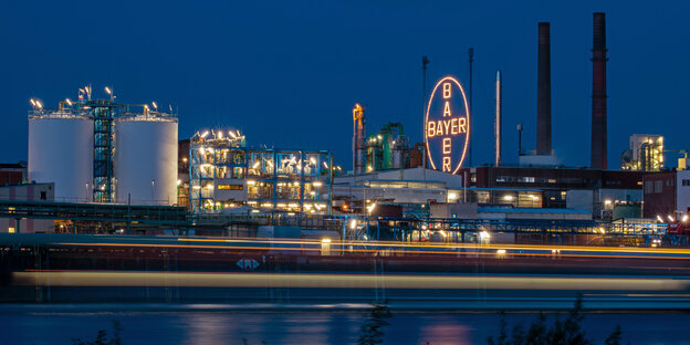 Das Logo des Unternehmens leuchtet auf dem Werksgelände von Bayer in Leverkusen.