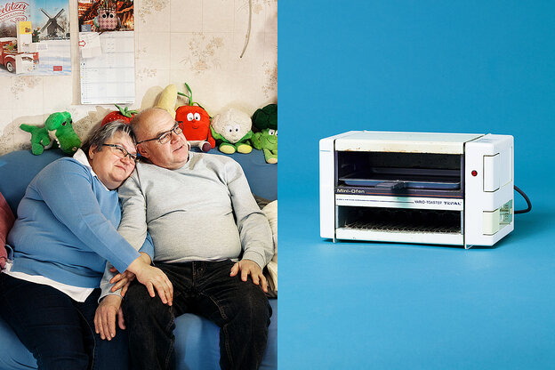 Altes Paar umschlungen auf einem Sofa, daneben ein Toaster