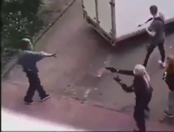 Screenshot aus dem Video: Der Mann, der später erschossen wird, geht mit ausgestreckter Hand auf die Polizist:innen zu; eine Polizistin zielt mit ihrer Waffe auf ihn