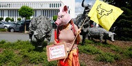 Eine AktivistIn demonstriert vor dem Fleischkonzern Tönnies