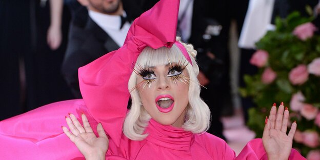 Sängerin Lady Gaga mit pinker Schleife im Haar und falschen Wimpern