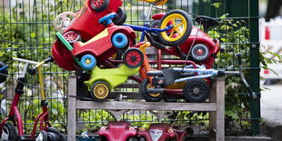 Mehrere Bobby-Cars stehen in einem Regal in einem Kindergarten