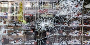 das zerschlagene Fenster eines Schuhgeschäfts