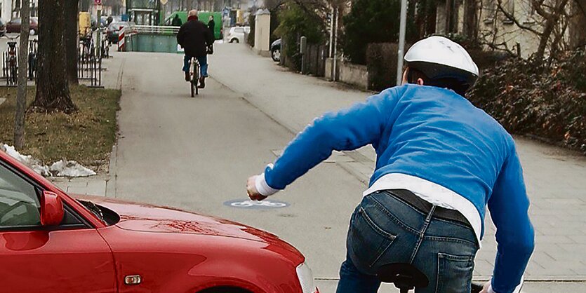 Ein Autofahrer nimmt einem Radfahrer die Vorfahrt.