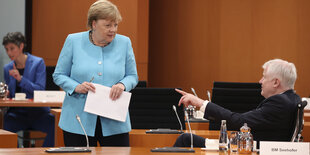 Merkel stehend, Seehofer sitzend