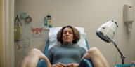 Eine Frau, sie heißt im Film Elpida, sitzt auf einem Gynäkologenstuhl