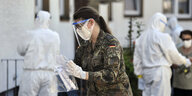 Bundeswehr Angestellte untersuchen Mitarbeiter der Fleischfabrik Toennies