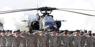 Amerikanische Soldaten saltuieren vor einem Hubschrauber
