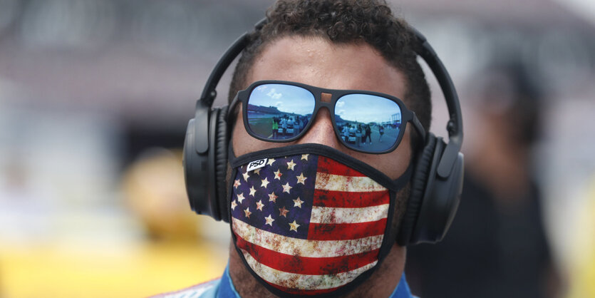 Fahrer Bubba Wallace mit Kopfhörern, Brille und Gesichtsmaske