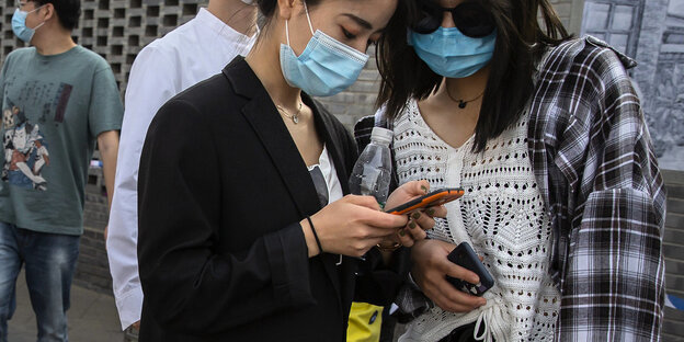 Zwei Frauen checken ihr Smartphone