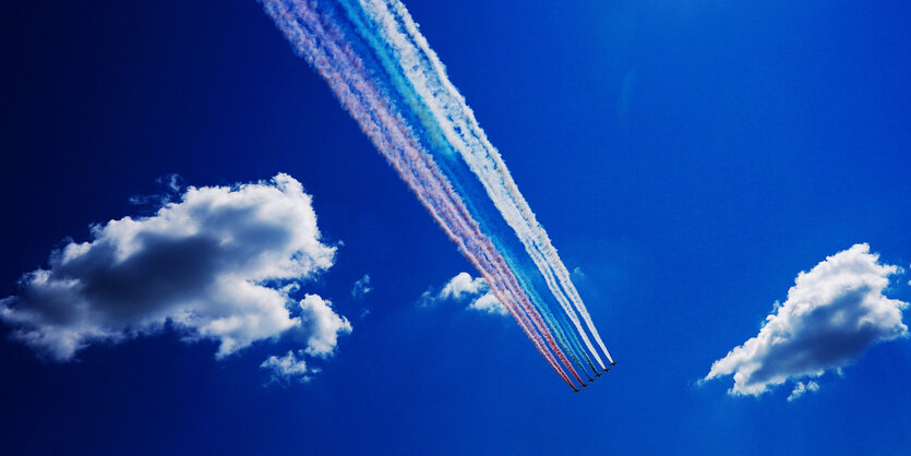 zwei Wolken und dazwischen fliegen Jets und hinterlassen die Farben der Rissichen Flagge