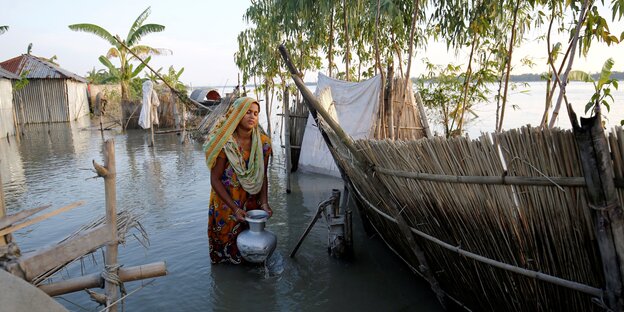 Klimawandel: Eine Frau sammelt Trinkwasser aus einem überfluteten Brunnen in Bogra, Bangladesch