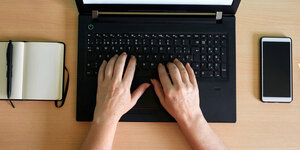 Hände auf der Tastatur eines Laptops