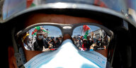 In der Sonnenbrille eines Soldaten spiegeln sich palästinensiche Demonstranten