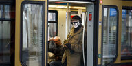 Mensch mir Totenkopfschutzmaske im Berliner Nahverkehr