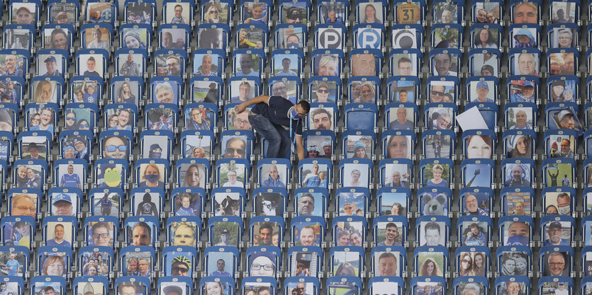 Leere Sitztribüne mit Fotos von Fans ausgelegt