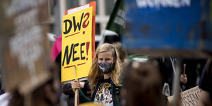 Demonstrantin hält auf einer Mietenwahnsinn-Demo ein Schild. Darauf steht: DW? Nee?