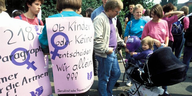 Menschen mit Plakaten bei einer Demonstration.