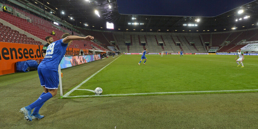 Ein Spieler führt einen Eckball im leeren Stadion aus