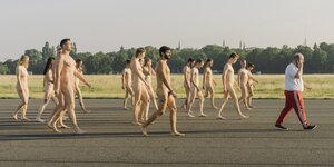 Eine Gruppe von Frauen und Männer geht nackt auf dem Tempelhifer Feld über eine alte Rollbahn - für eine Kunstaktion