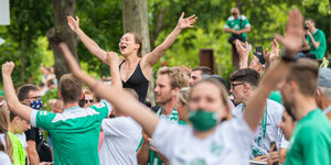 Werder-Fans recken die Arme jubelnd in die Höhe