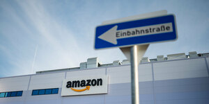 Ein Einbahnstraßenschild ist vor dem Amazon Schriftzug am Logistikzentrum in Winsen (Luhe)
