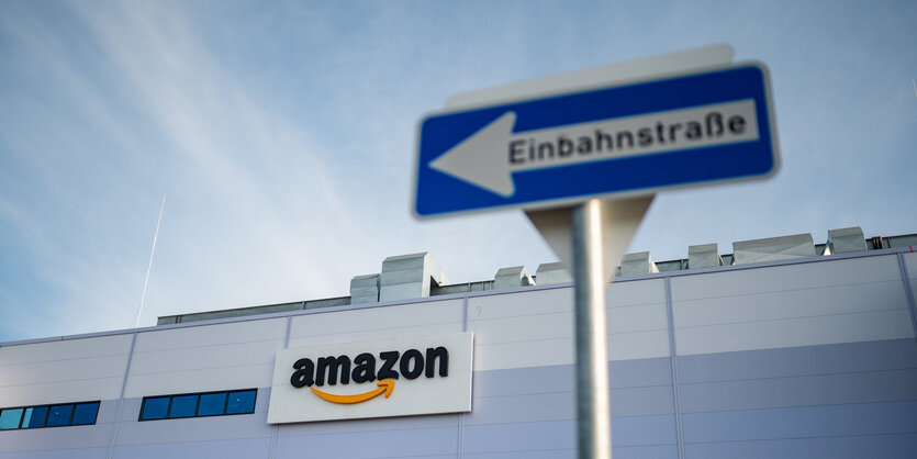 Ein Einbahnstraßenschild ist vor dem Amazon Schriftzug am Logistikzentrum in Winsen (Luhe)