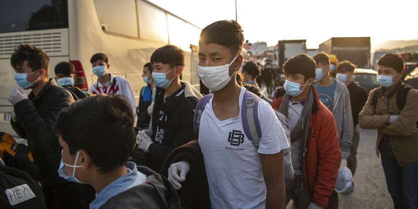 Griechenland, Athen: Eine Gruppe unbegleiteter Kinder aus überfüllten griechischen Flüchtlingslagern tragen Schutzmasken, während sie mit einer Fähre im Hafen von Piräus ankommen.