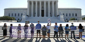 Eine Menschenkette mit Plakaten steht vor dem Gebäude des Obersten US-Gerichtshofes