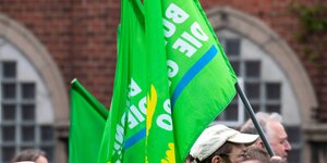 Menschen mit günen Fahnen auf einer Demonstration.