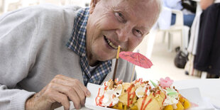 Ein älterer Mann mit einem großen Eis.