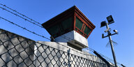 Wachturm hinter dem Stacheldraht eines Gefängnisses