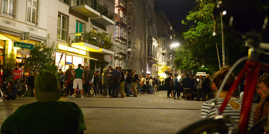 Viele Menschen stehen vor einem Kiosk auf der Straße