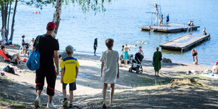 Menschen gehen zu einem Badestrand.